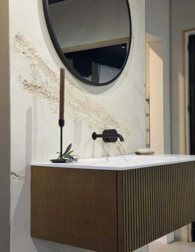 Contemporary ribbed wood vanity with round mirror and black tap in Derby bathroom