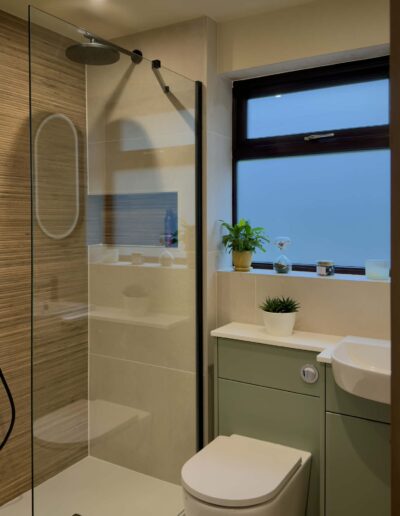 Modern walk-in shower with green vanity unit and frosted window in Derby bathroom