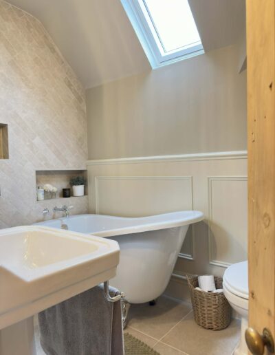Traditional freestanding bath under skylight with panelled walls in Derby bathroom