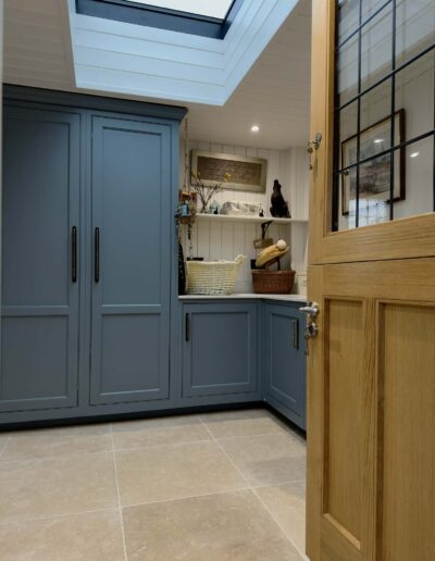 Blue shaker style utility room with storage and skylight in Derby home
