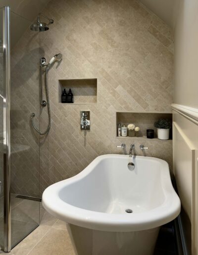 Freestanding bath with beige herringbone tiles and built-in niches in Derby bathroom